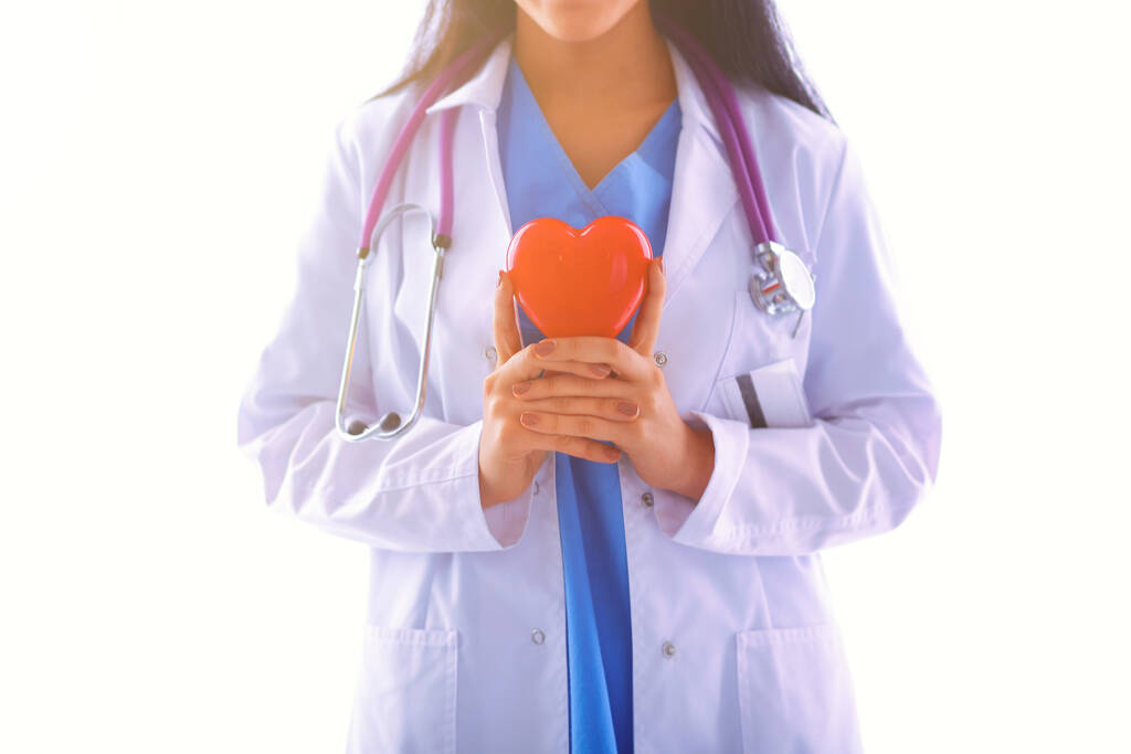 Ärztin mit Stethoskop, das Herz hält, isoliert auf weißem Hintergrund - Foto, Bild