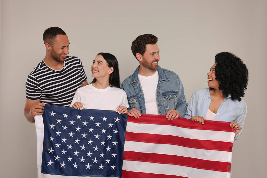 4 липня - День незалежності США. Щасливі друзі з американським прапором на сірому тлі - Фото, зображення