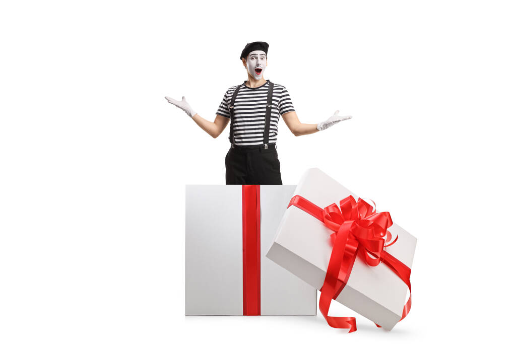 Mime wewnątrz pudełka z prezentami wykonując niespodziankę izolowane na białym tle - Zdjęcie, obraz