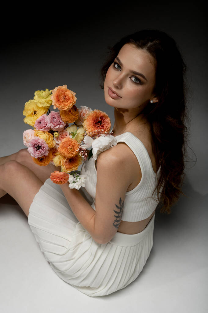 πορτρέτο της μόδας νεαρή γυναίκα ποζάρουν στο στούντιο με λουλούδια - Φωτογραφία, εικόνα