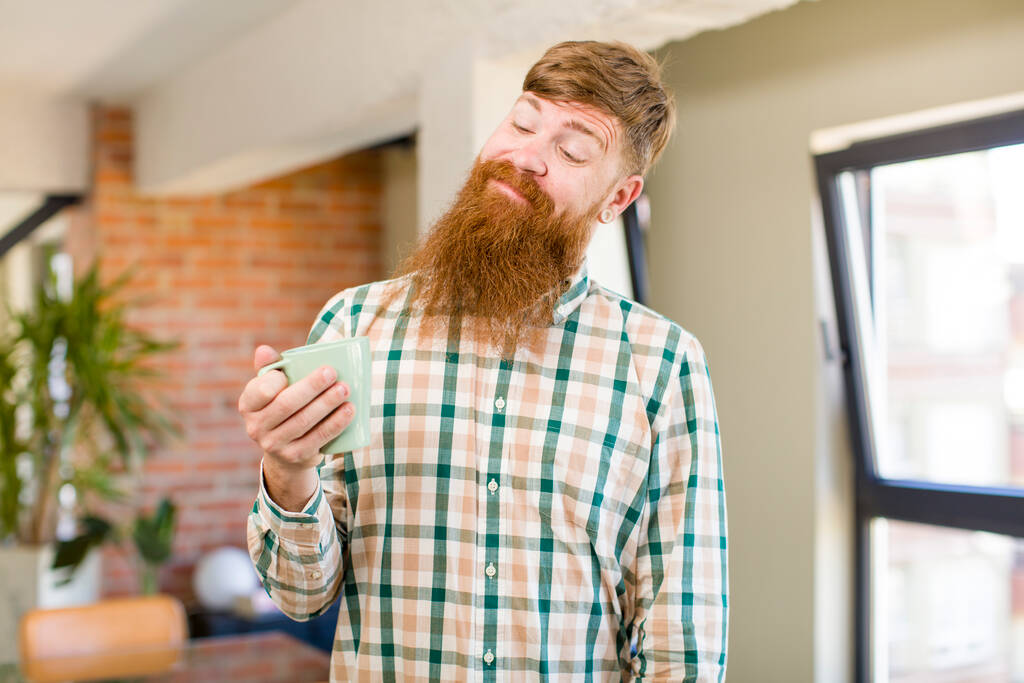 zrzavé vlasy muž zrzavé vlasy muž s úsměvem a při pohledu se šťastným sebejistý výraz s hrnkem kávy - Fotografie, Obrázek