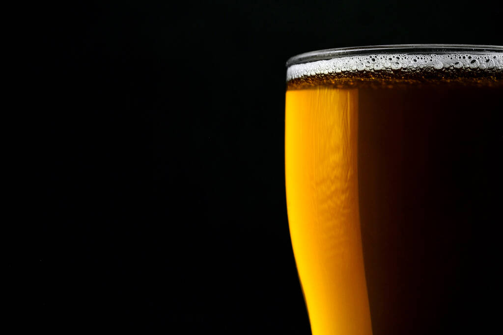 Glass of fresh beer isolated on a black background. Close-up. - Photo, Image