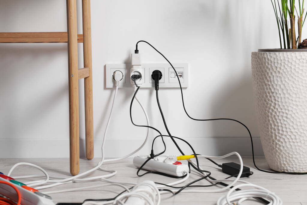 Различные электрические розетки в розетке и силовой полосе на полу в помещении - Фото, изображение