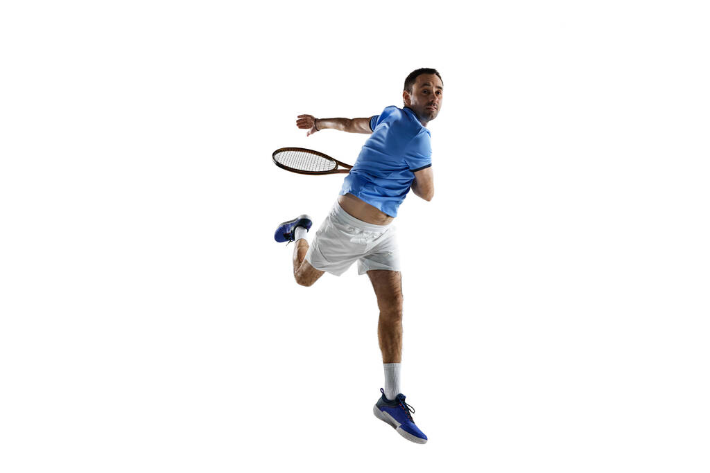 Imagem dinâmica do homem concentrado, tenista profissional em movimento com raquete isolada sobre fundo branco. Conceito de esporte, estilo de vida ativo, jogo, hobby, saúde, dinâmica, anúncio - Foto, Imagem