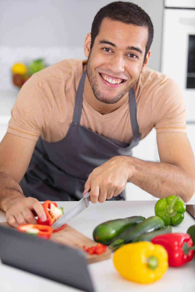 Jóképű férfi főzés otthon készít saláta a konyhában - Fotó, kép