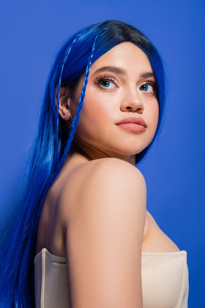 Schönheitsfotografie, junge Frau mit gefärbten Haaren posiert auf blauem Hintergrund, Haarfarbe, glühende Haut, weibliches Model mit Make-up und trendiger Frisur, lebendige Jugend, Hautperfektion  - Foto, Bild