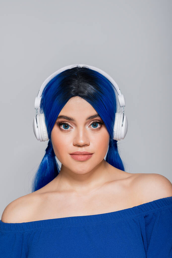 коханка музики, молода жінка з яскравим волоссям слухає музику в бездротових навушниках на сірому фоні, молодь, індивідуалізм, сучасна субкультура, самовираження, звук  - Фото, зображення