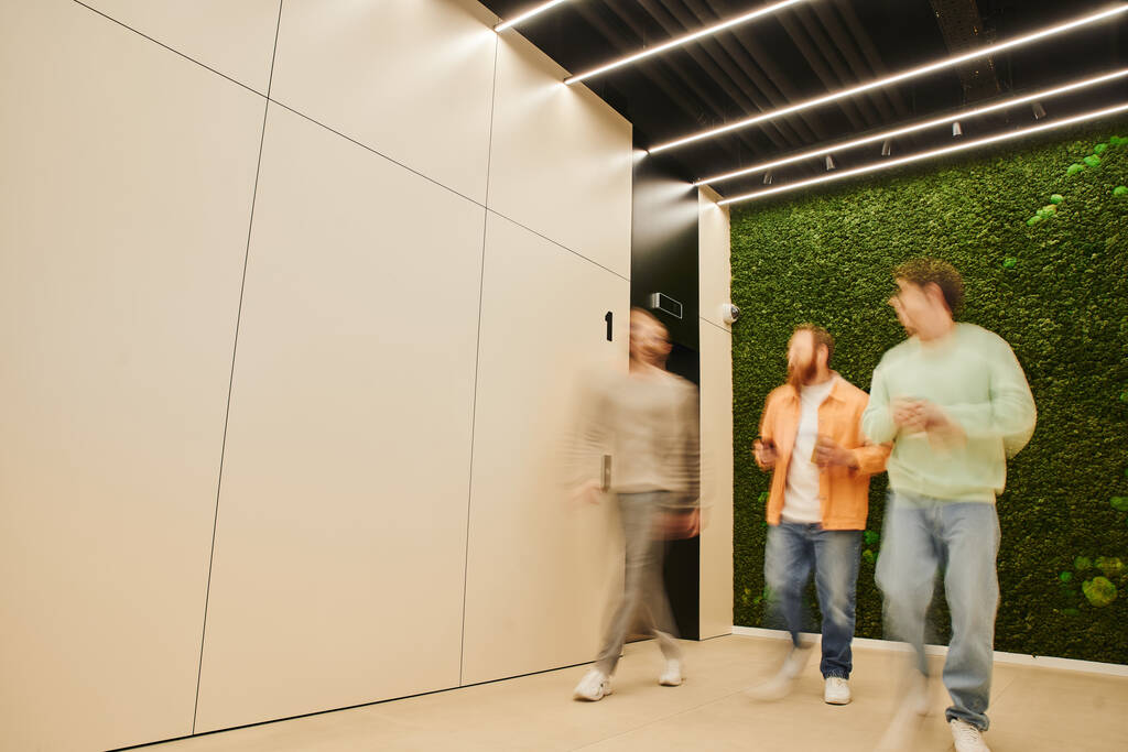 motion blur of creative business partners walking along corridor in modern coworking space with high tech interior, talking and planning business project, collaboration and partnership concept - Photo, Image