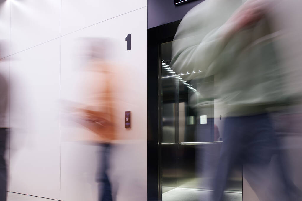 lunga esposizione di uomini d'affari che camminano vicino all'ascensore con porte aperte nell'ufficio di coworking contemporaneo con interni ad alta tecnologia, movimento, business dinamico, produttività - Foto, immagini