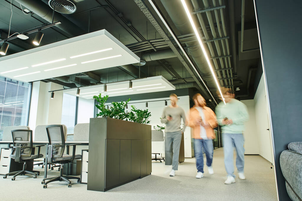group of creative business partners walking in modern and spacious coworking space with high tech interior, contemporary furniture and green natural plants, movement, long exposure - Photo, Image
