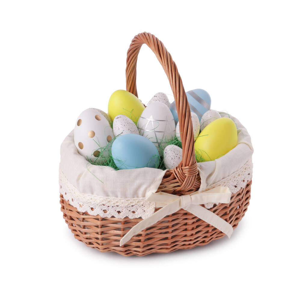 Плетеная корзина с красиво окрашенными пасхальными яйцами изолированы на белом - Фото, изображение