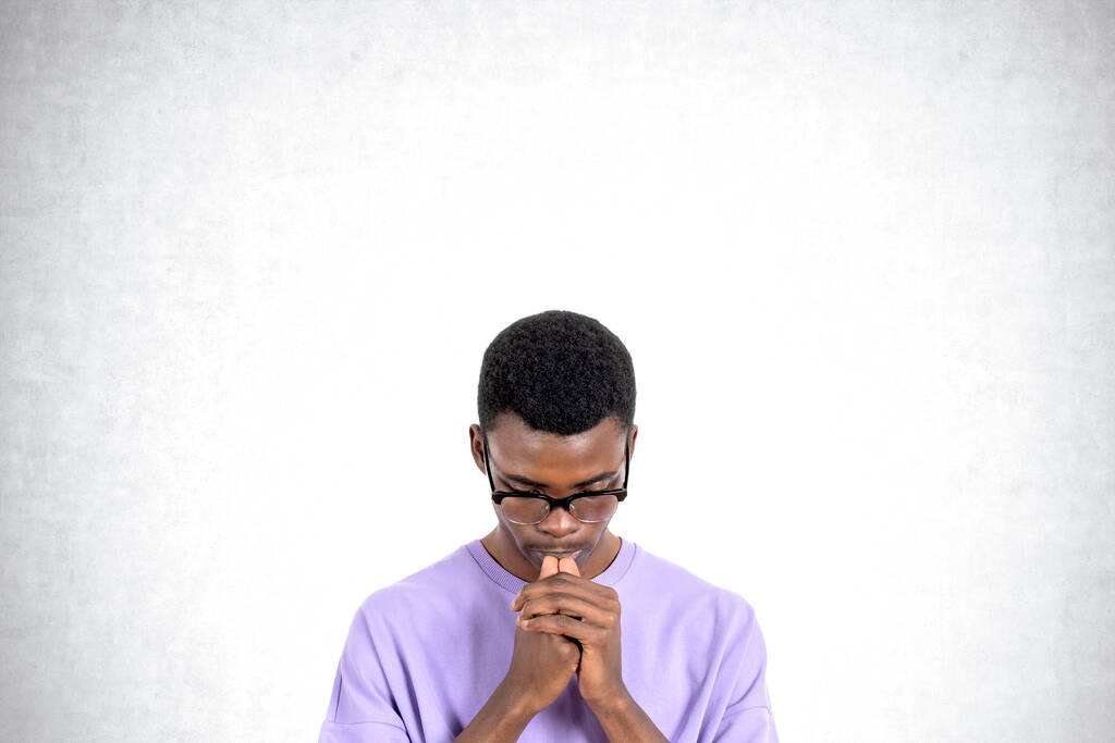 Портрет молодого африканского студента колледжа в повседневной одежде и очках, размышляющего упорно, стоя на бетонном фоне. Концепция решения проблем и выбора карьеры - Фото, изображение