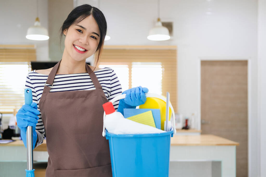  Millennial Magd hält Eimer mit Putzmitteln drinnen, Nahaufnahme der Hände. Ausgeschnittene Ansicht der Hausfrau mit Reinigungsmitteln, bereit für die Hausreinigung. Sanitärdienstleistungskonzept - Foto, Bild