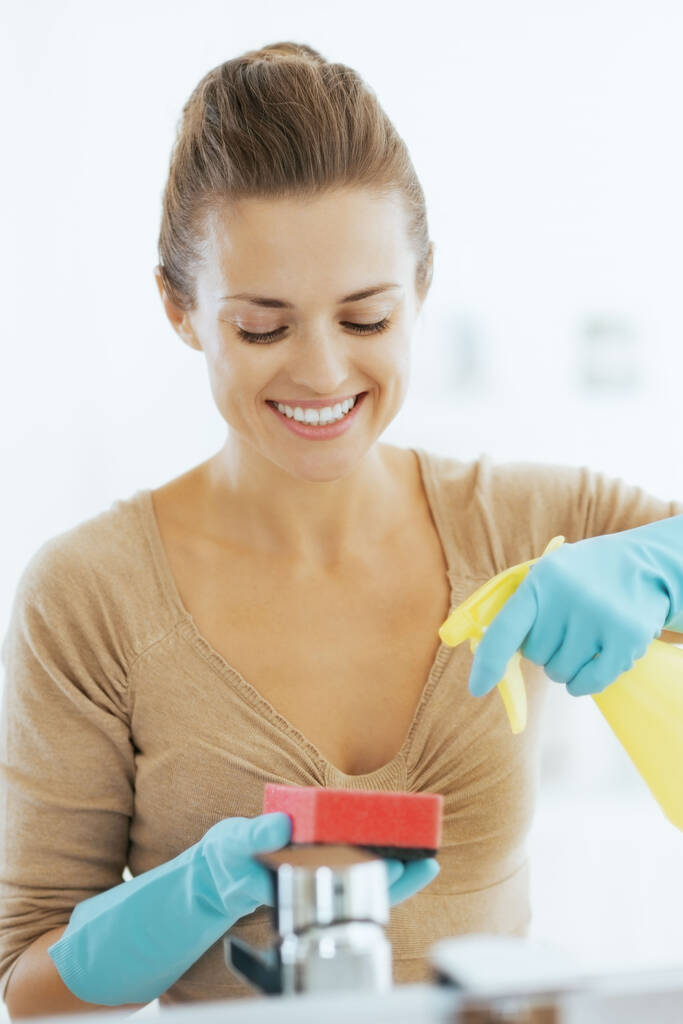 Gelukkig jonge huisvrouw reinigen in de badkamer - Foto, afbeelding