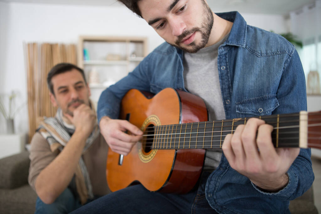 tiener leren spelen van een gitaar - Foto, afbeelding