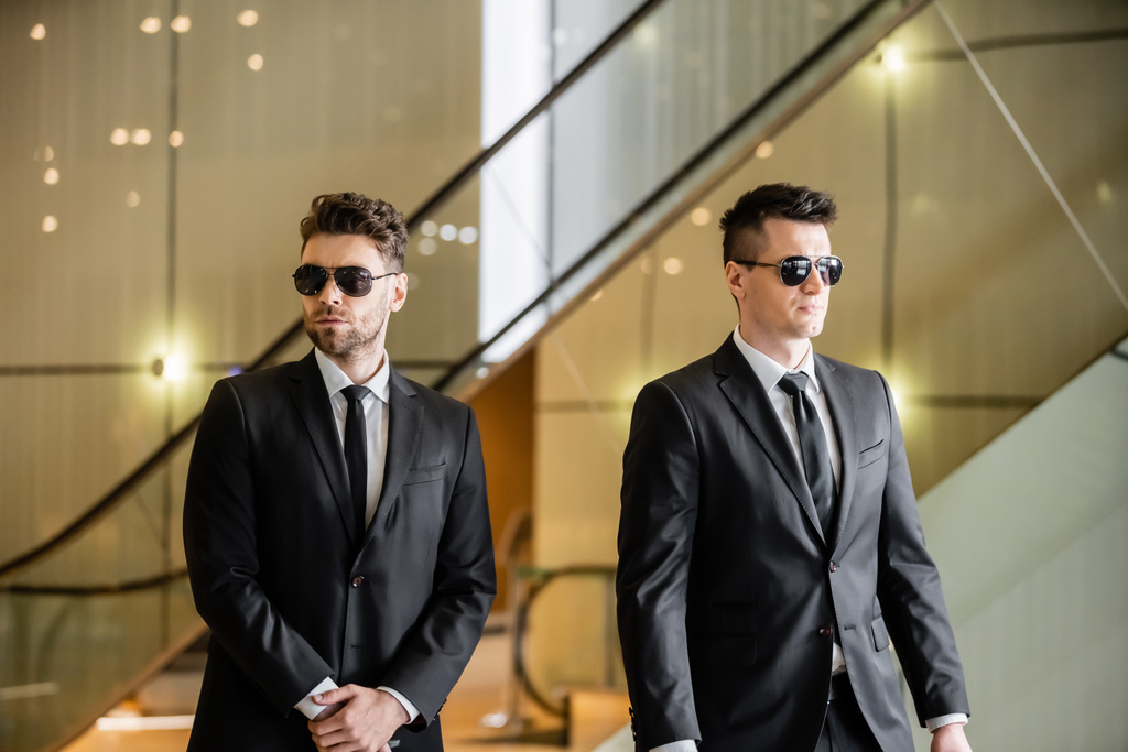 security measures of luxury hotel, two handsome men in formal wear and sunglasses, bodyguards on duty, safety management, vigilance, suits and ties, private security, strong guards  - Photo, Image
