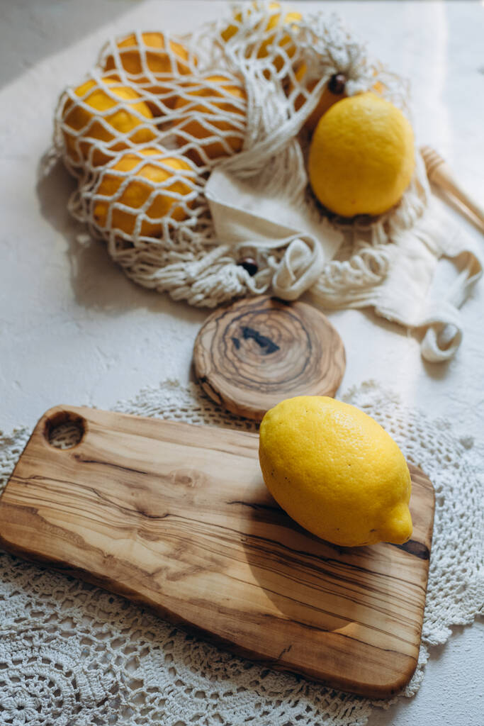 Citrusový citron krájený na plátky na dřevěné desce na bílém pozadí - Fotografie, Obrázek