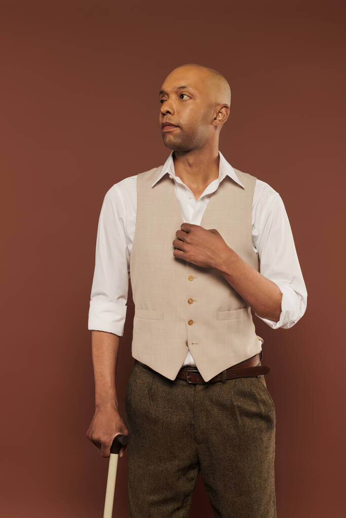 αληθινοί άνθρωποι, τολμηρός Αφροαμερικάνος άνδρας με μυασθένεια gravis στέκεται με το μπαστούνι σε καφέ φόντο, σκούρο δέρμα, ποικιλομορφία και ένταξη, σωματική βλάβη  - Φωτογραφία, εικόνα