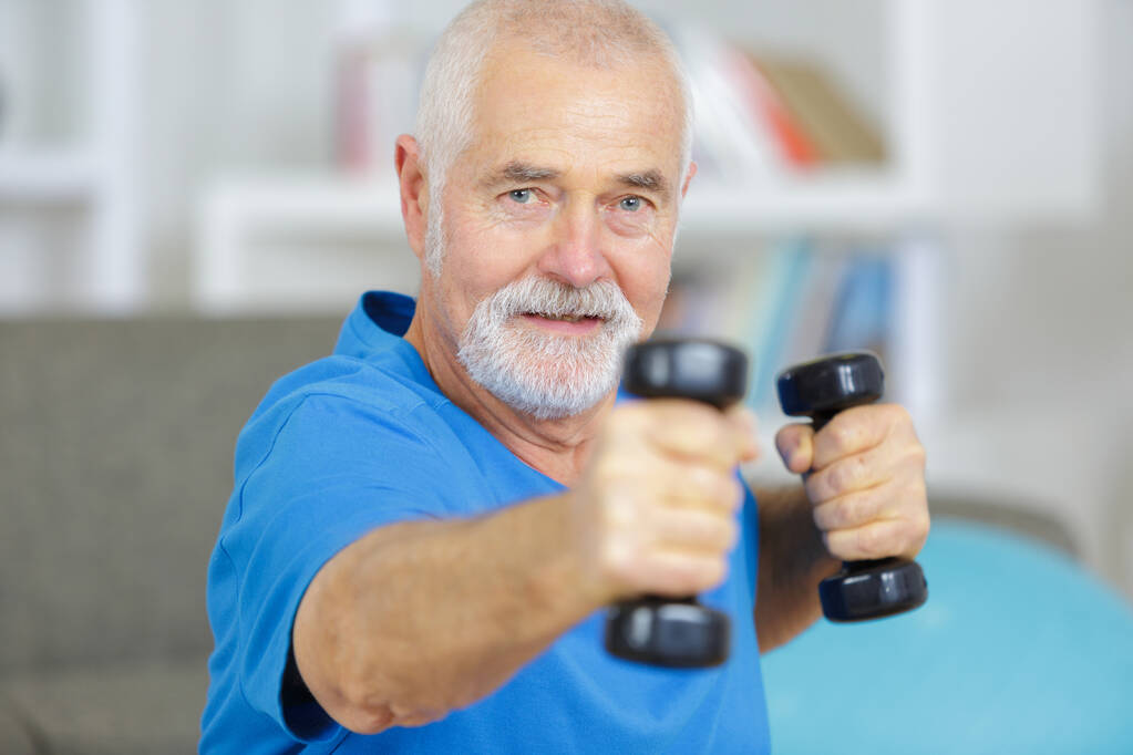 anciano haciendo ejercicio con pesas en casa - Foto, imagen