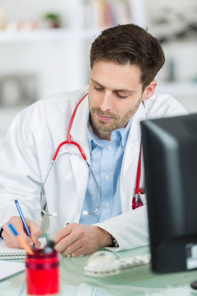 médico masculino que escreve a prescrição para o paciente na mesa - Foto, Imagem