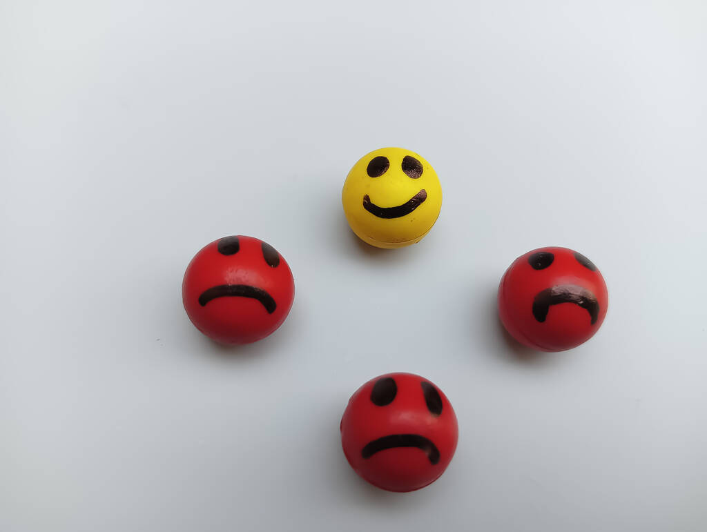 One happy face and three sad faces on white background  - Photo, Image