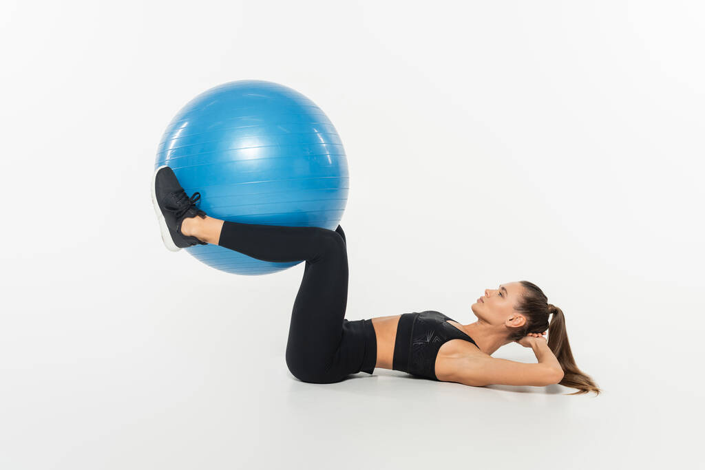 žena ve sportovním oblečení trénink s fitness míčem na bílém pozadí, zdravý a fit koncept - Fotografie, Obrázek