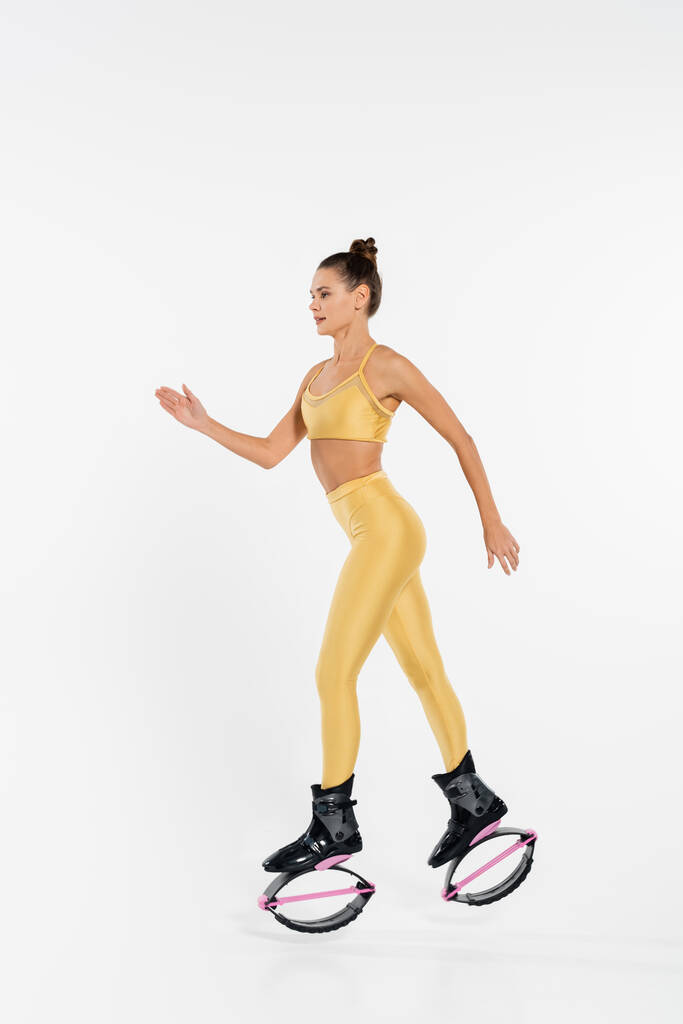 nő fitness ruházat visel kenguru jumping cipő, tónusú test, motiváció, jumping csizma  - Fotó, kép