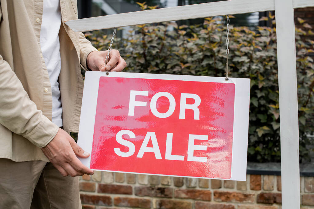 vista parcial del letrero colgante del agente inmobiliario con letras para la venta al aire libre - Foto, Imagen