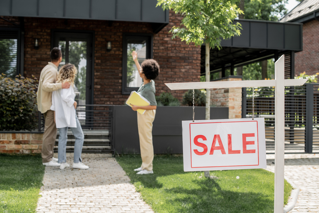 Afrikanisch-amerikanischer Immobilienmakler zeigt Haus an umarmendes Paar in der Nähe zum Verkauf - Foto, Bild