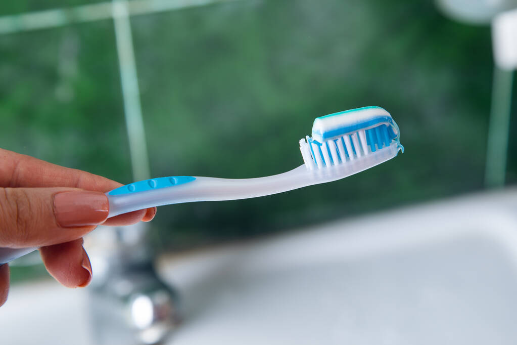 жінка рука зубна паста на пензлі на ванній - Фото, зображення