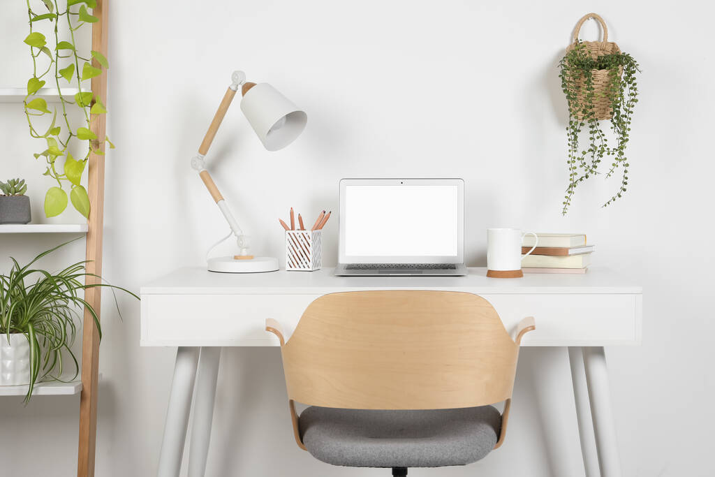 Espaço de trabalho acolhedor com laptop, lâmpada e papelaria em mesa de madeira em casa - Foto, Imagem