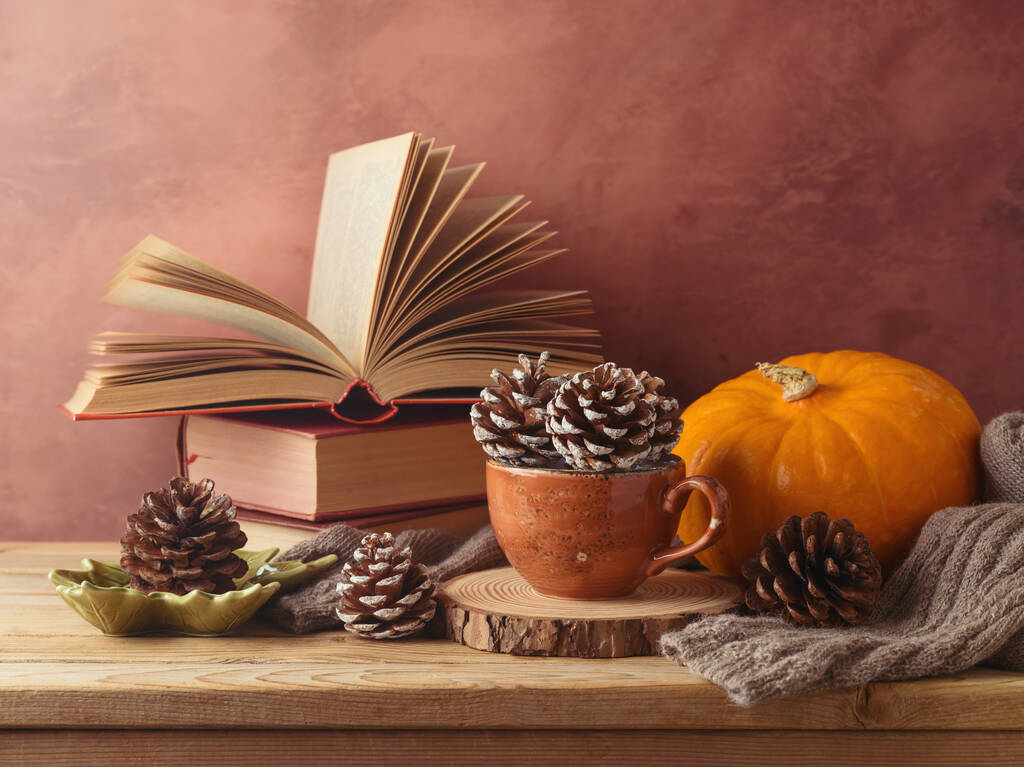 Conceito de outono com cone de pinho em xícara de café, abóbora e livros em mesa de madeira. Cartão de saudação de Ação de Graças - Foto, Imagem