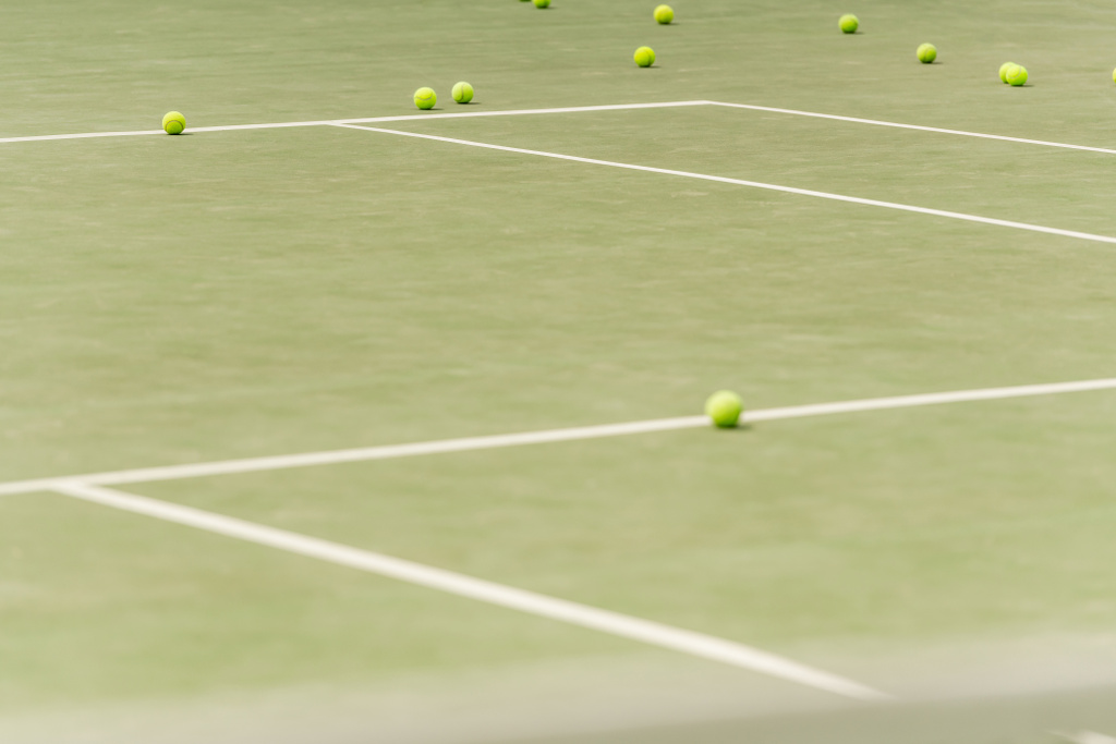 Никто в кадре, теннисные мячи на просторном корте, размытый передний план, лето, спорт и отдых - Фото, изображение