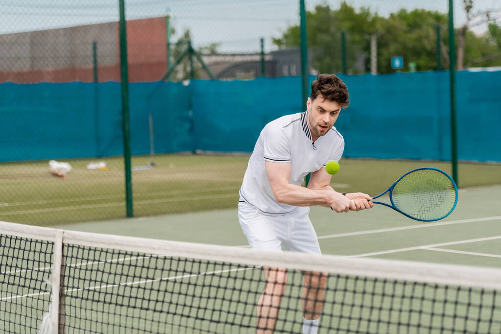 красивий чоловік грає в теніс на корті, літнє хобі і спорт, мотивація, спортсмен - Фото, зображення