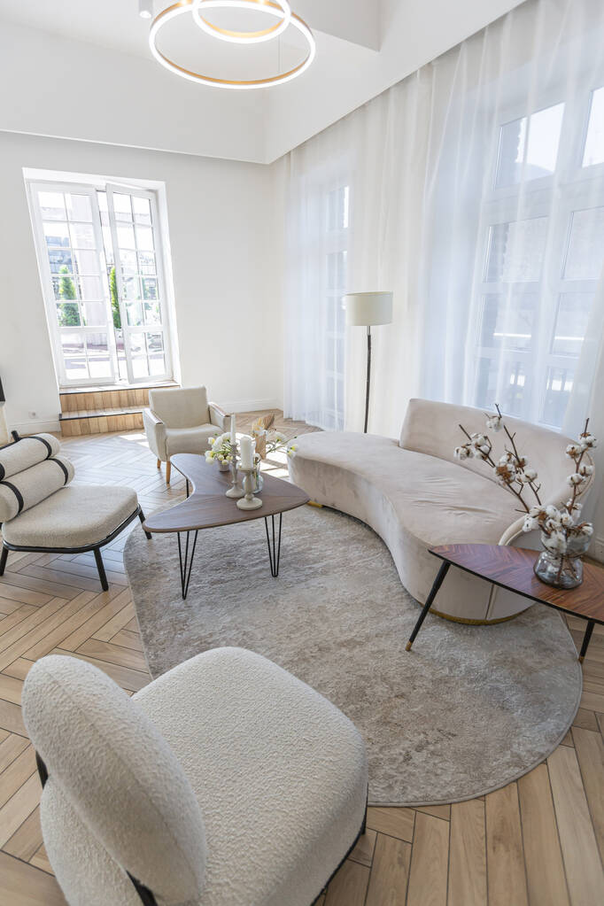 Kreativer Couchtisch und modische Polstermöbel im Wohnzimmer in einer geräumigen, offenen Wohnung mit stilvollem, modernem, hellen Design an einem sonnigen Tag - Foto, Bild