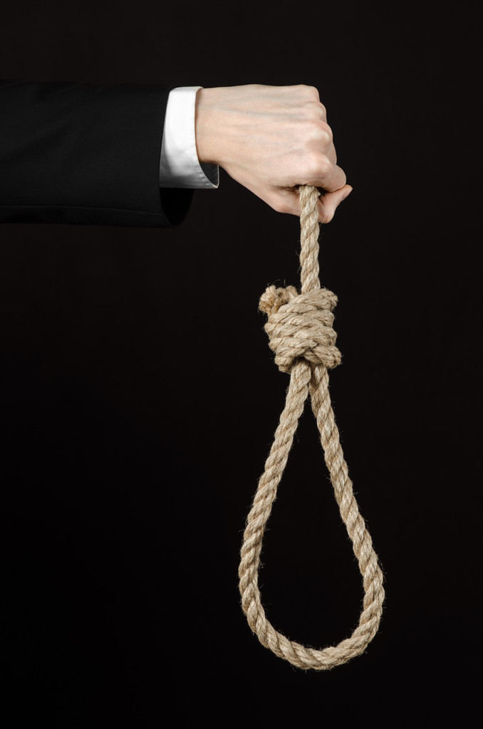 Selbstmord und geschäftliches Thema: Hand eines Geschäftsmannes in schwarzer Jacke mit einer Seilschlaufe zum Aufhängen auf schwarzem, isolierten Hintergrund - Foto, Bild
