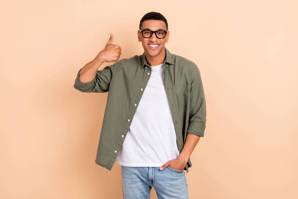 Photo of positive nice guy toothy smile arm fingers demonstrate thumb up approval isolated on beige color background. - Photo, Image