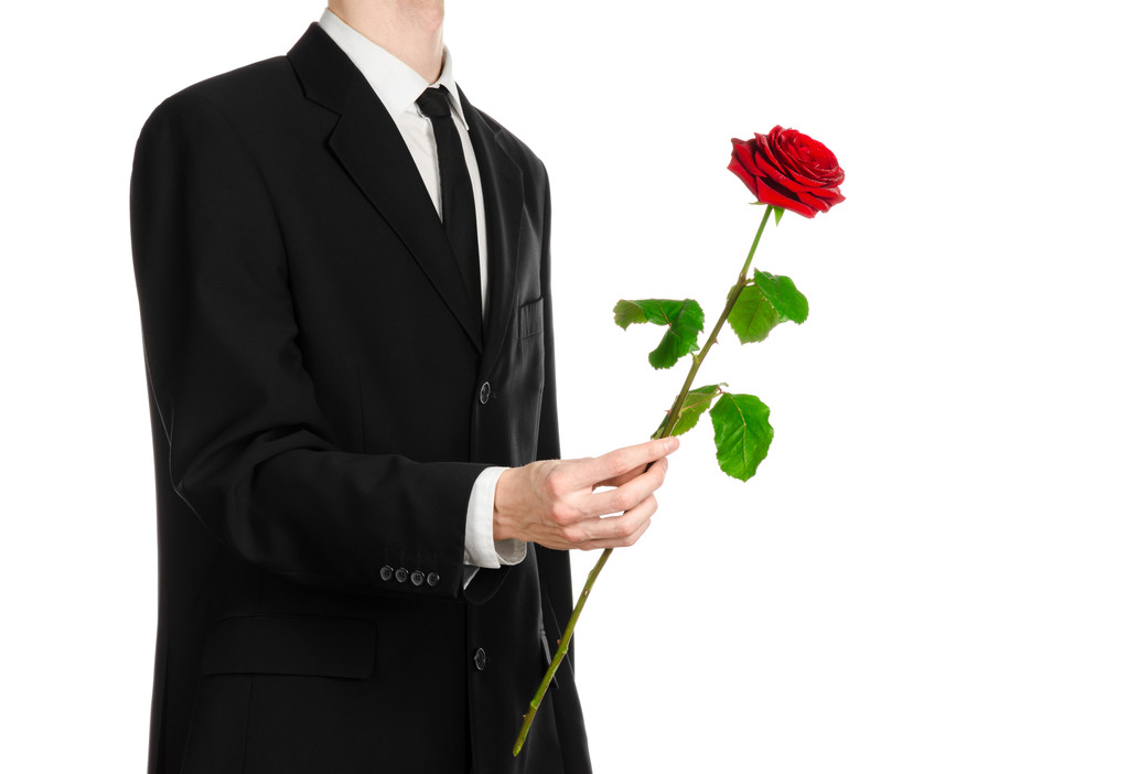 Valentýna a žen den téma: ruka v obleku drží červená růže izolovaných na bílém pozadí v studio - Fotografie, Obrázek