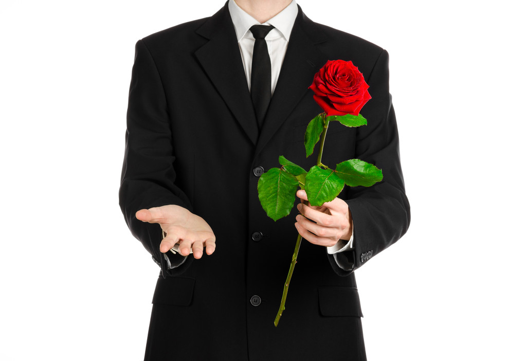 День Святого Валентина і жіночий день тема: рука людини в костюмі Холдинг червоні троянди ізольовані на білому тлі в студії - Фото, зображення