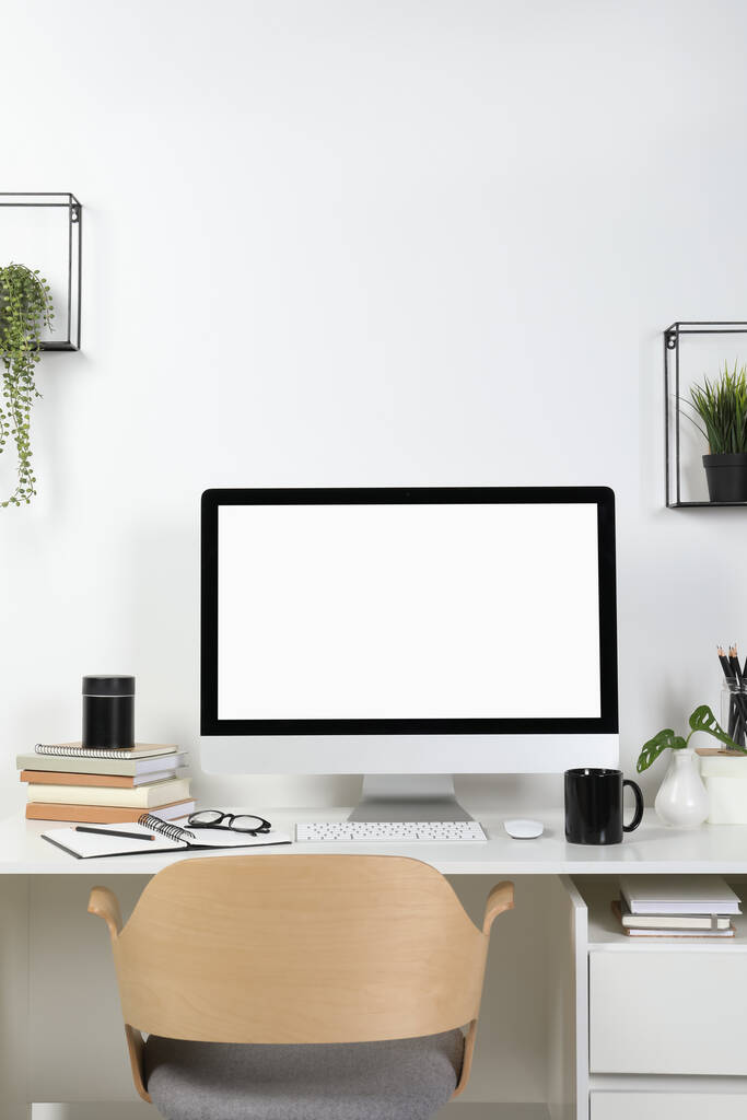 Acogedor espacio de trabajo con computadora y papelería en escritorio de madera en casa - Foto, imagen
