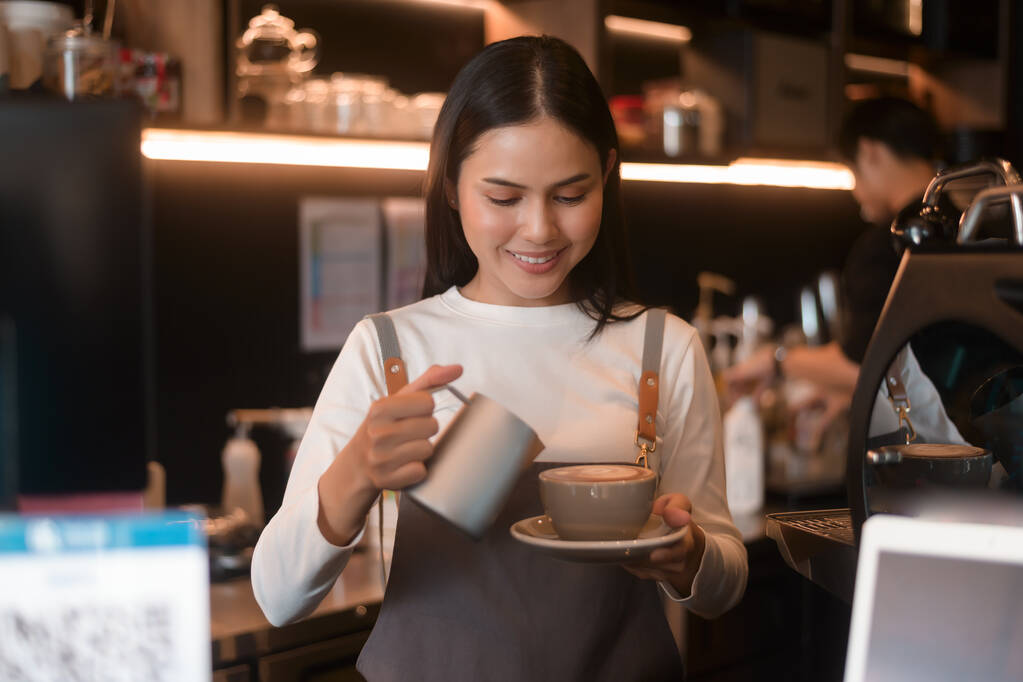 Egy fiatal nő barista dolgozik a modern kávézóban.  - Fotó, kép