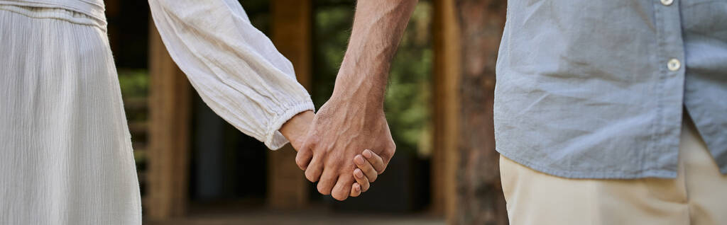 spandoek, vrouw in zonnejurk hand in hand met man, wazig zomerhuis, liefde en romantiek, bijgesneden - Foto, afbeelding