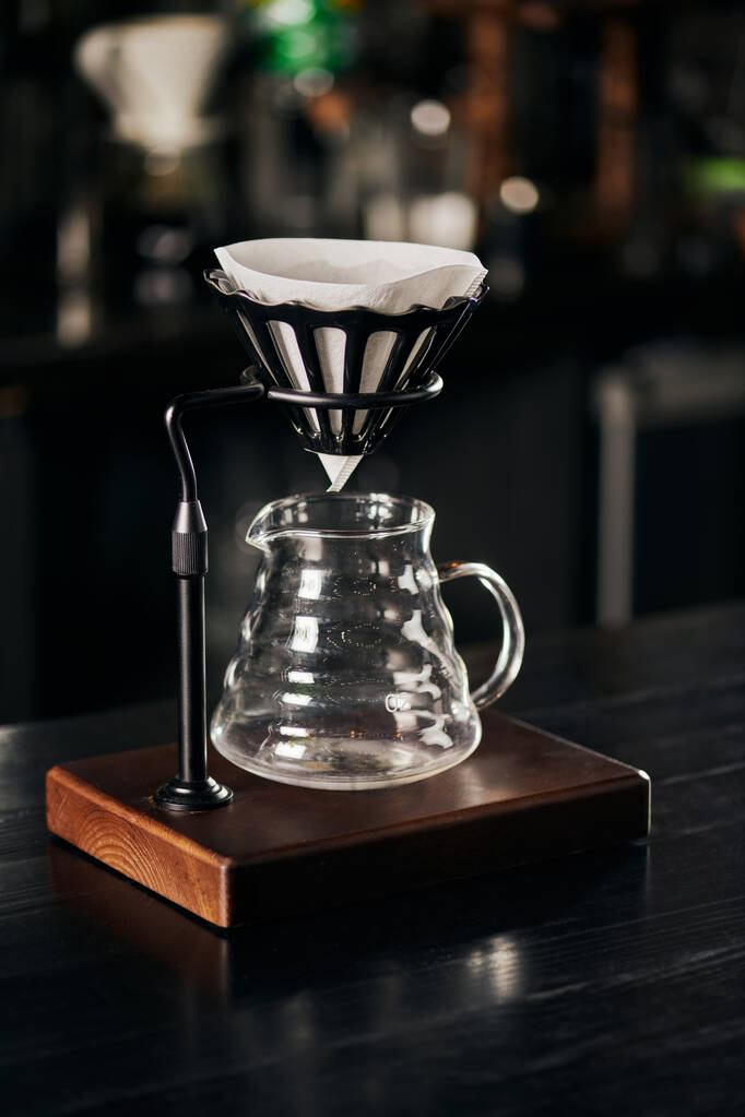 Serum tutacağı filtre torbasıyla, cam kahve demliği siyah ahşap tezgahta, alternatif V-60 tarzı metot - Fotoğraf, Görsel