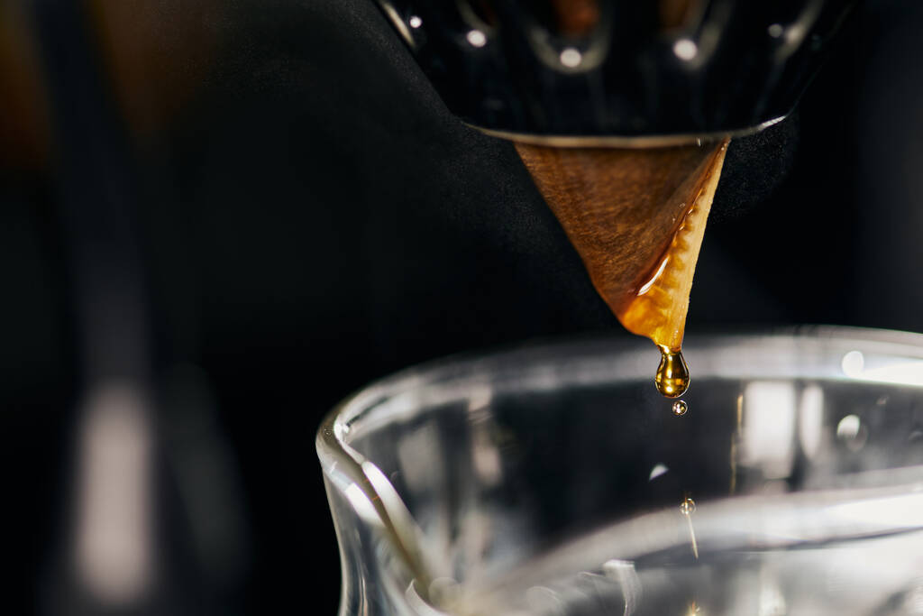 zbliżenie widok kapania espresso z filtra papierowego na stojaku kroplowym do szklanego garnka, metoda V-60 - Zdjęcie, obraz