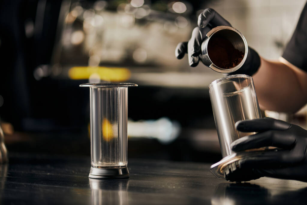 vista parziale di barista preparare pour-over espresso e versando caffè macinato in aero press - Foto, immagini