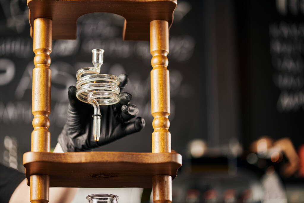 barista em luva de látex preto segurando parte espiral da máquina de café cerveja fria, método alternativo - Foto, Imagem
