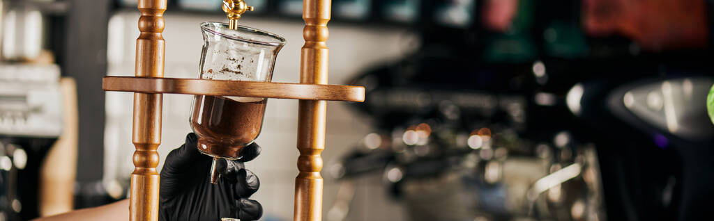 частичный вид бариста в черной перчатке с холодной капельной кофеваркой с молотым кофе, баннер - Фото, изображение