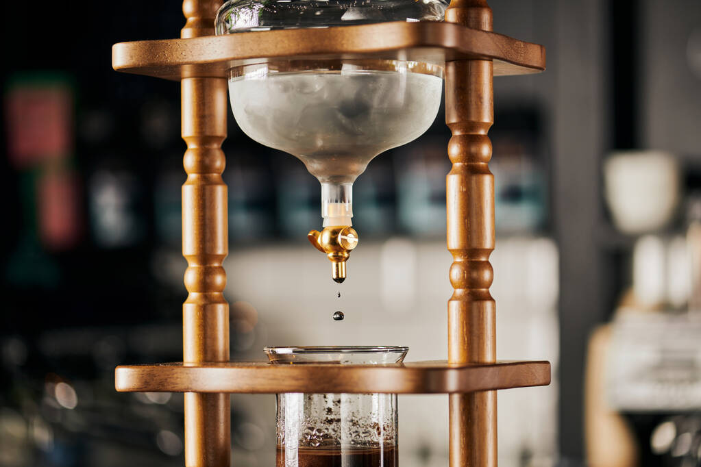 alternatief zetten van espresso, koud druppelkoffiezetapparaat, koud water druppelend op verse gemalen koffie  - Foto, afbeelding