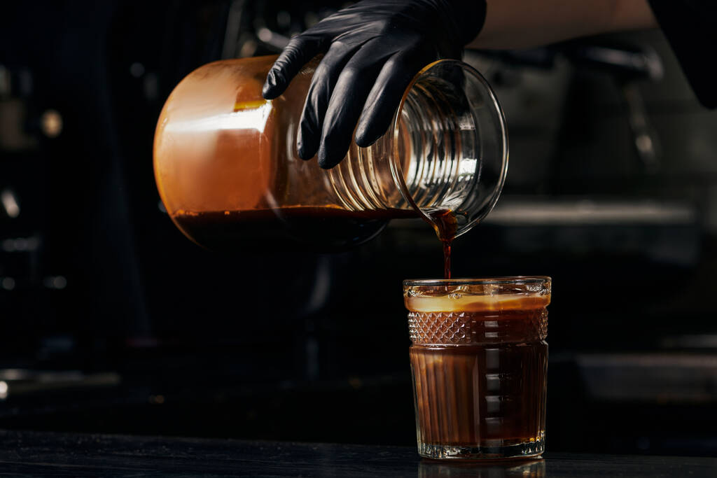 наливая эспрессо в апельсиновый сок, освежающий напиток, кофе, бариста заставляя шмель пить  - Фото, изображение