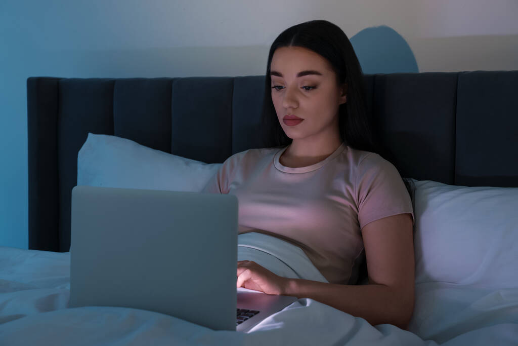 Jeune femme utilisant un ordinateur portable au lit la nuit. Dépendance à Internet - Photo, image